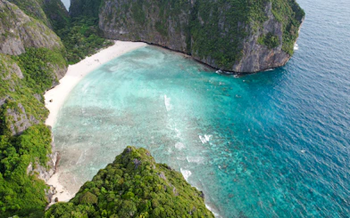 Aerial view of Maya Bay's turquoise waters and limestone cliffs at sunrise, Krabi.