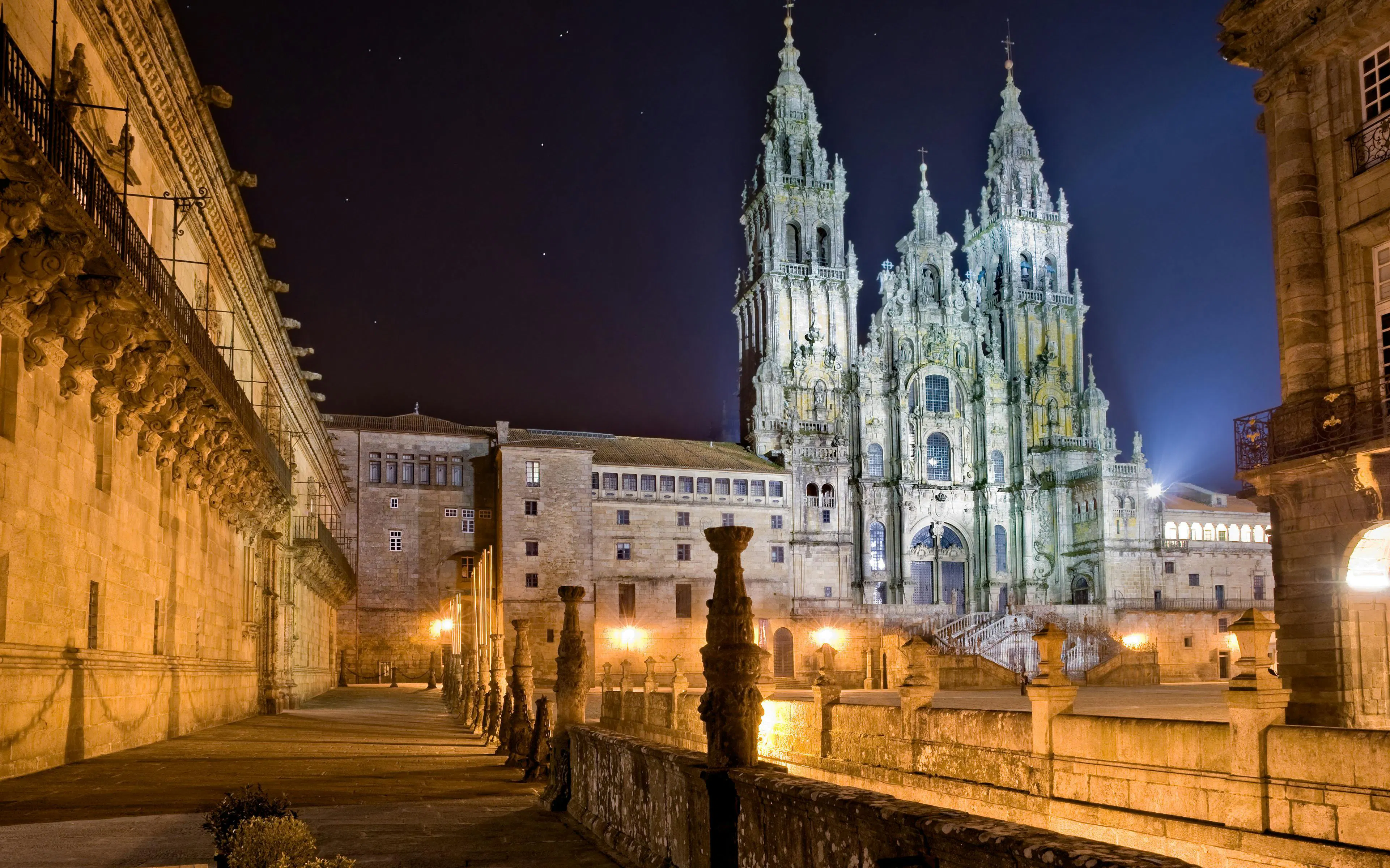 Cathedral of Santiago de Compostela illuminated at night, showcasing its intricate architecture.