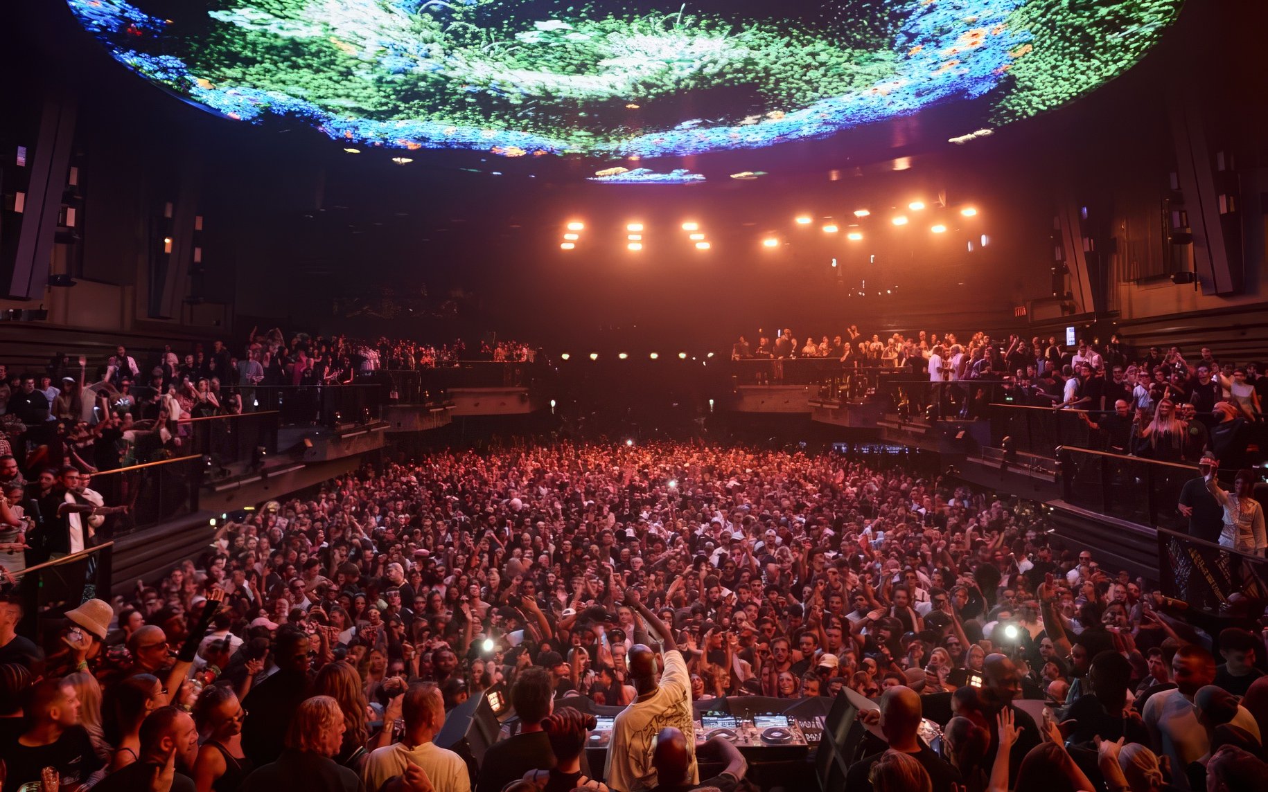 Black Coffee DJ set at UNVRS Ibiza with a large crowd and vibrant light display.