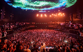 Black Coffee DJ set at UNVRS Ibiza with a large crowd and vibrant light display.