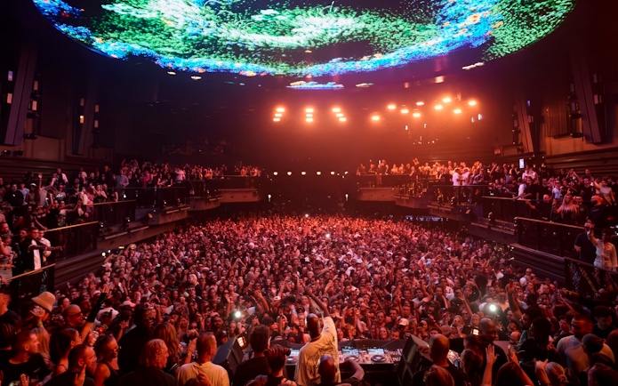 Black Coffee DJ set at UNVRS Ibiza with a large crowd and vibrant light display.