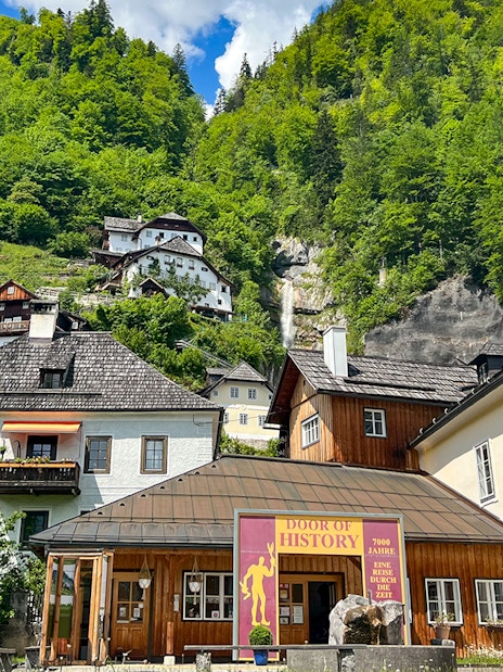 Hallstatt village buildings with lush green hills, seen on a day trip from Vienna.