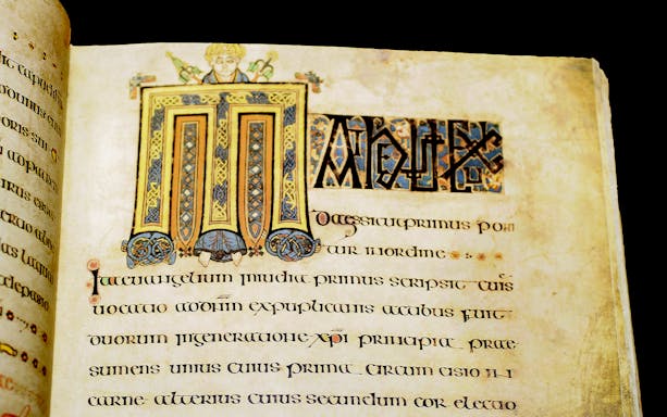 Illuminated page from the Book of Kells manuscript with intricate designs and Latin text.