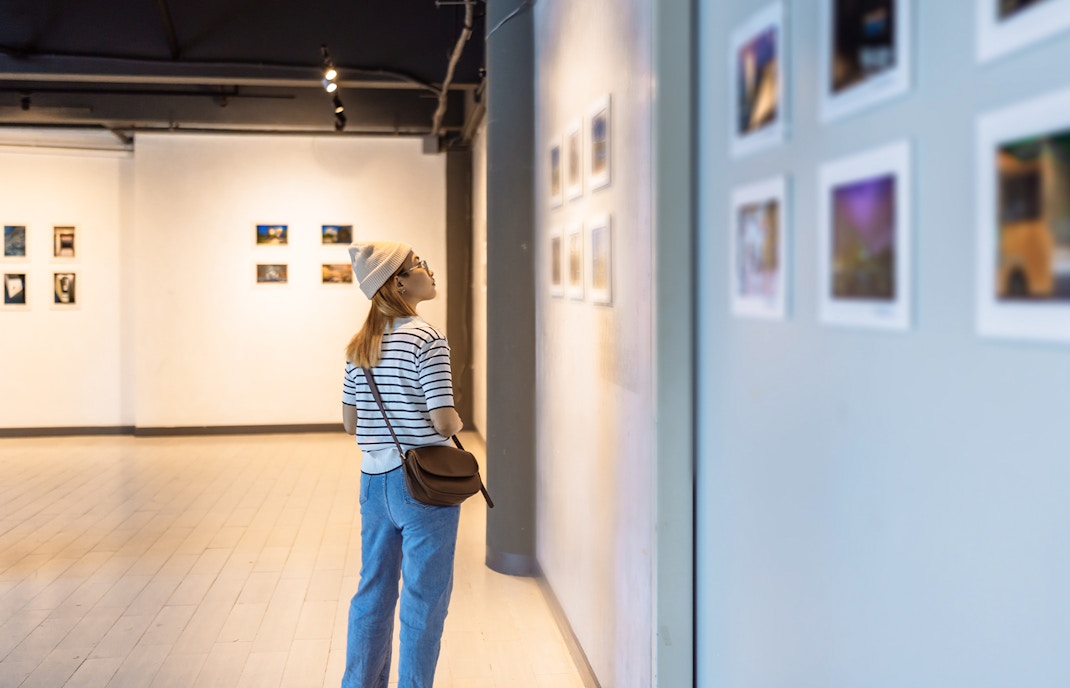 Visitor observing artwork in a museum gallery.