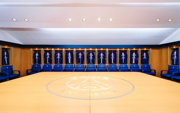 PSG Stadium locker room with team jerseys on display, Paris, France.