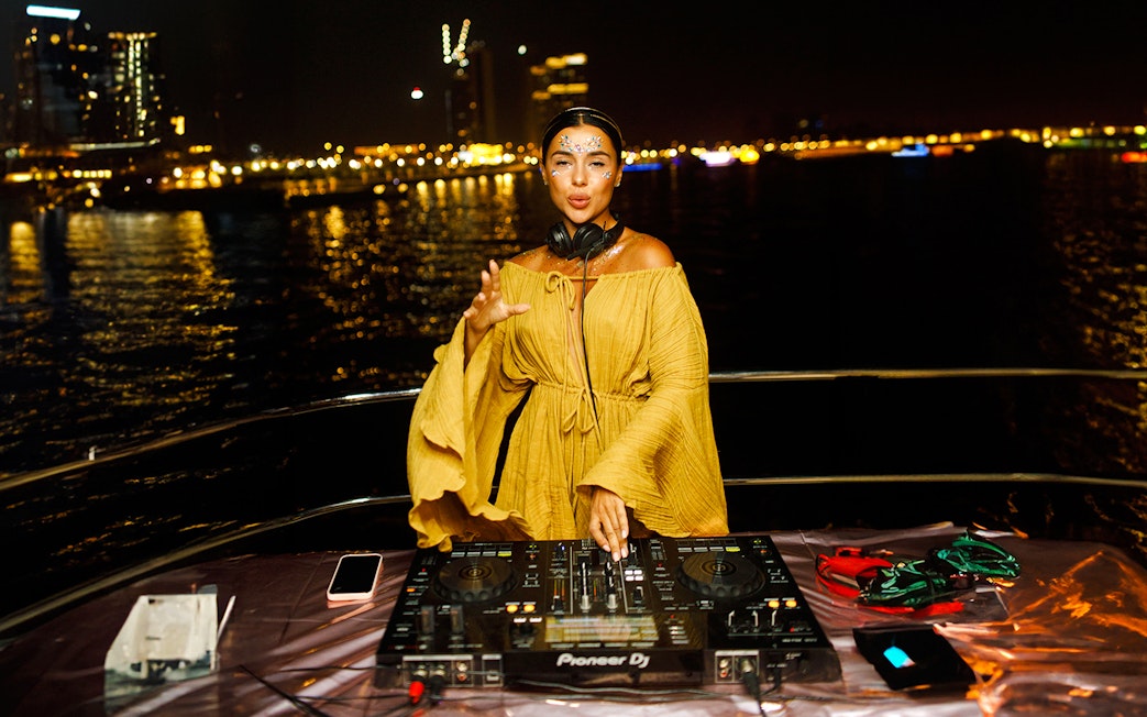 DJ performing on a yacht at night during Dubai Sunset Yacht Tour.