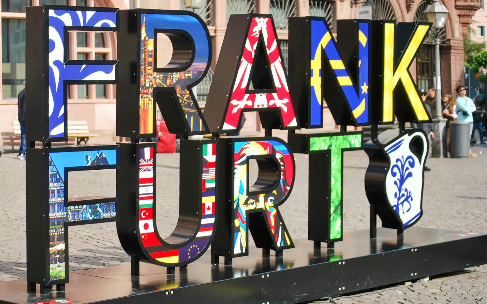 Colorful Frankfurt sign with international flags in a public square.