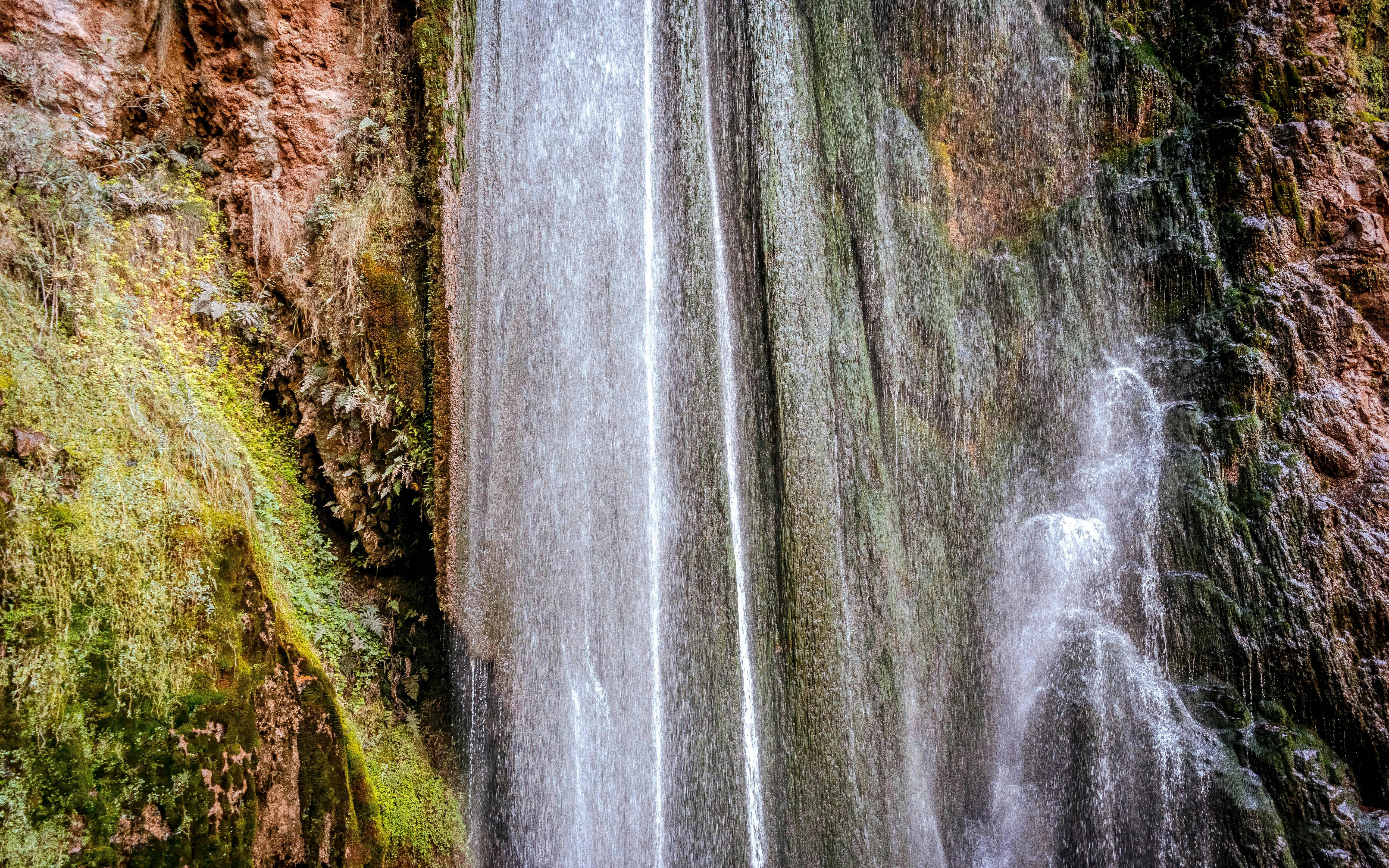 Perolniyoc waterfall cascading over mossy rocks in Ollantaytambo, Peru.