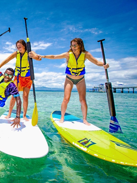 Friends paddle surfing at Malamala Beach Club, Fiji.