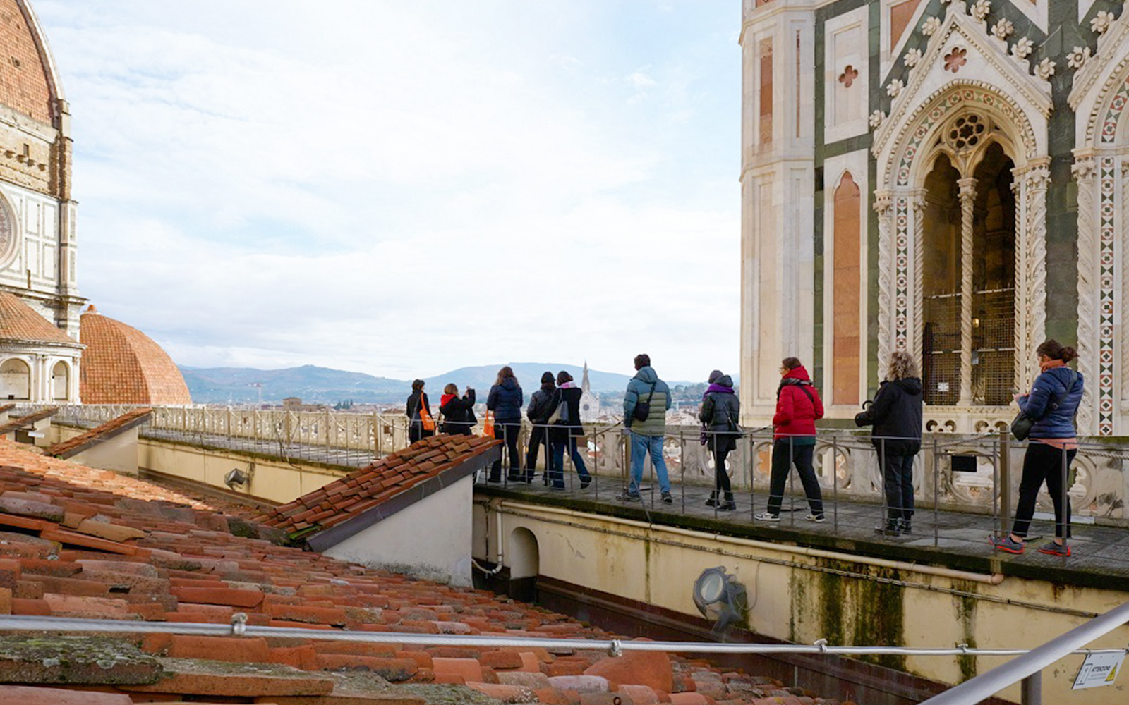 Visitors with a guide on the terrace of Florence Cathedral, Italy.