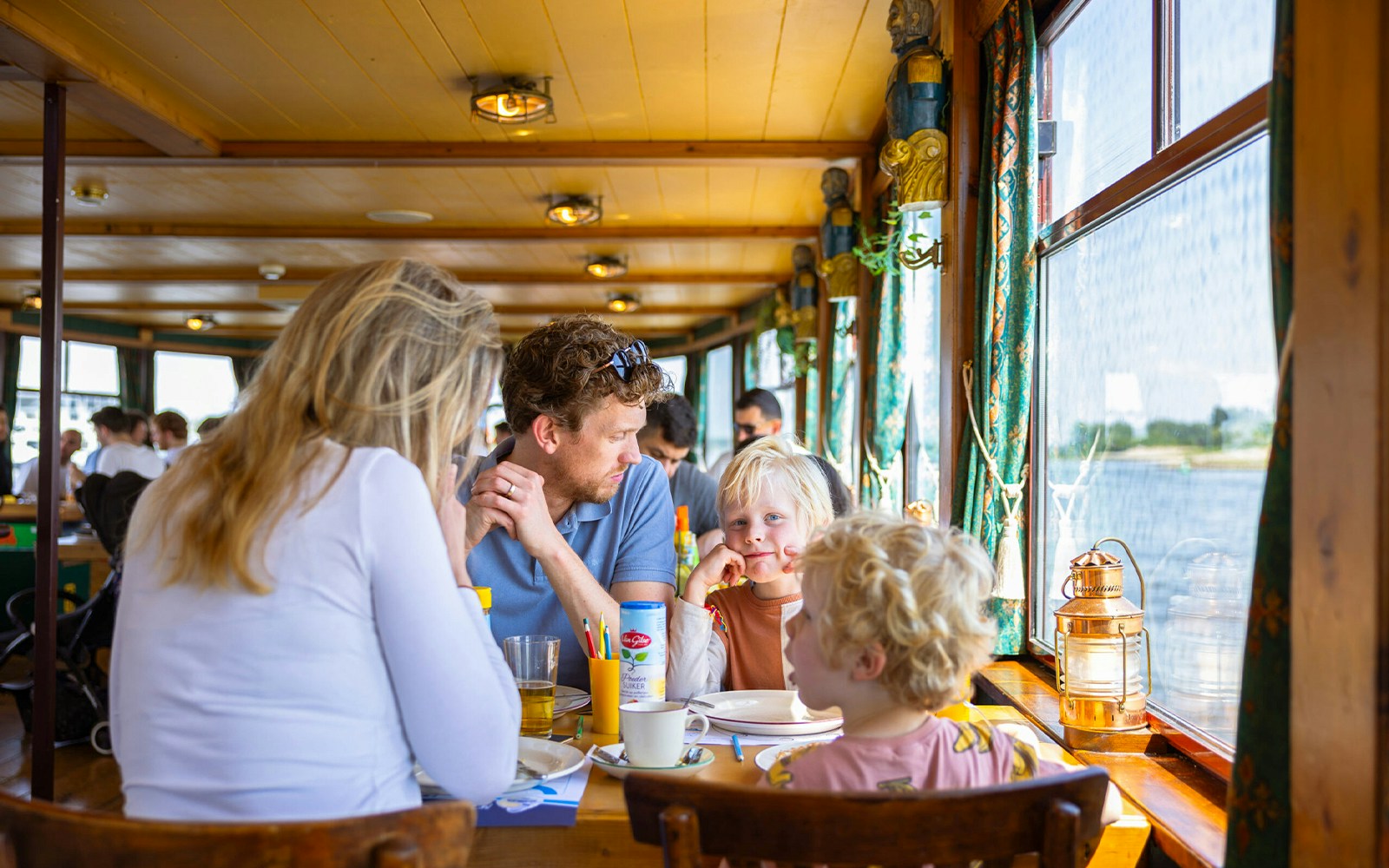 Guests enjoying the Pancake Cruise on a boat in Rotterdam with city skyline in the background.