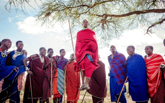 Maasai villagers performing traditional dance in Zanzibar, wearing colorful attire.