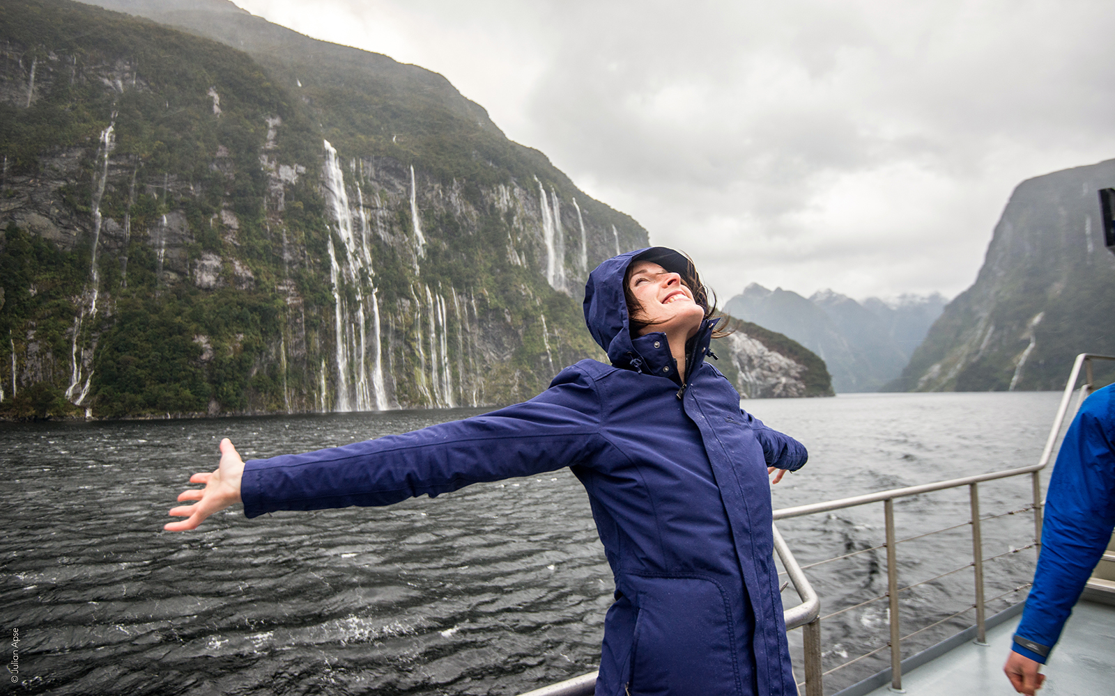 Cruise passenger enjoying scenic waterfalls on Doubtful Sound, New Zealand.