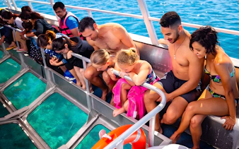 Tourists on a glass-bottom boat viewing Moore Reef, Great Barrier Reef.