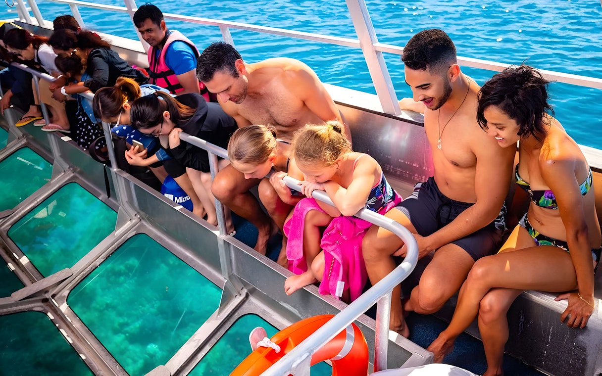 Tourists on a glass-bottom boat viewing Moore Reef, Great Barrier Reef.