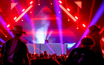 DJ performing at Emirates Dubai 7s Sunroom Hospitality event with vibrant lights.
