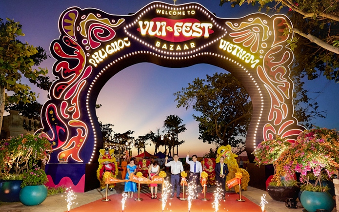 Tourists at Vui Fest Bazaar entrance on Phu Quoc Island, Vietnam, with cultural performances.