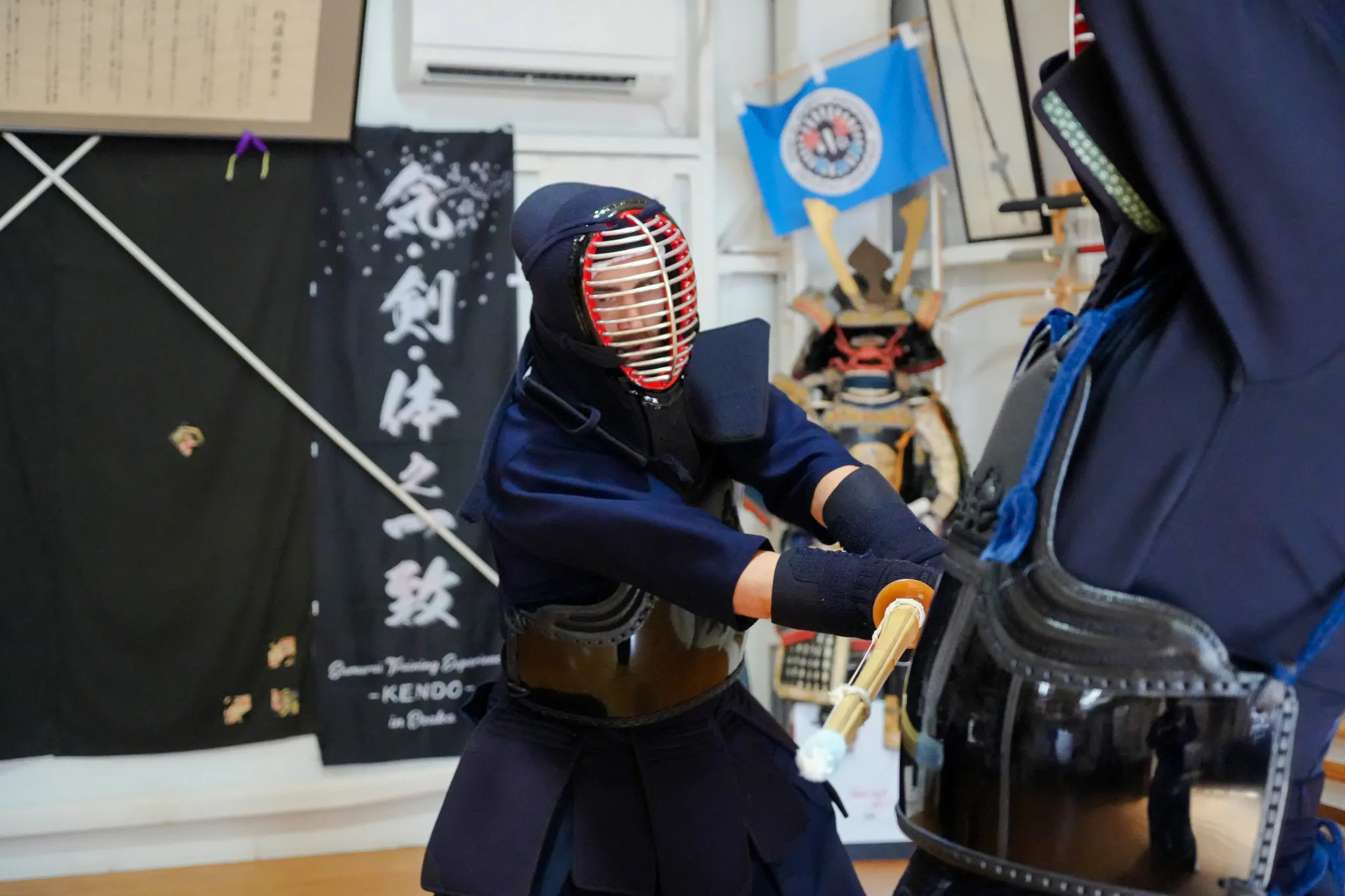 Kendo practitioner in armor during samurai training in Osaka dojo.