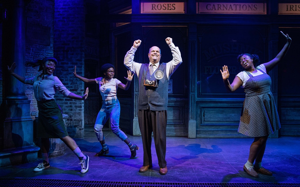 Performers on stage in a scene from "Little Shop of Horrors" musical.