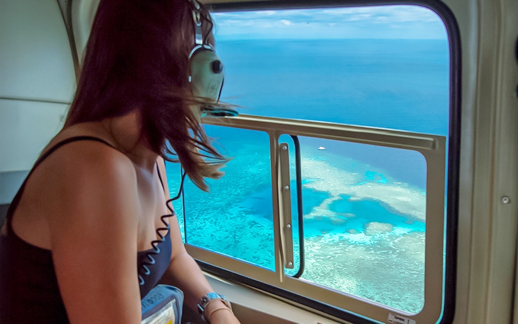 Woman enjoying Great Barrier Reef view from helicopter.