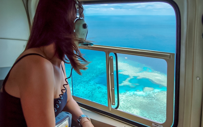 Woman enjoying Great Barrier Reef view from helicopter.