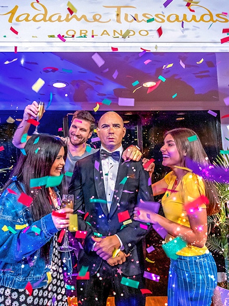 Tourists celebrating with Pit Bull wax statue at Madame Tussauds Orlando.