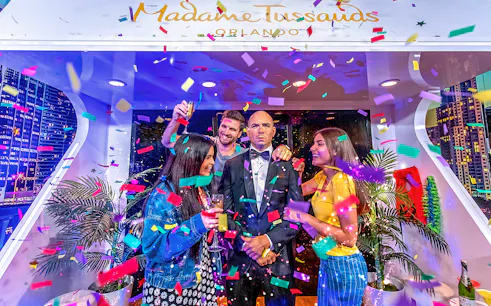Tourists celebrating with Pit Bull wax statue at Madame Tussauds Orlando.