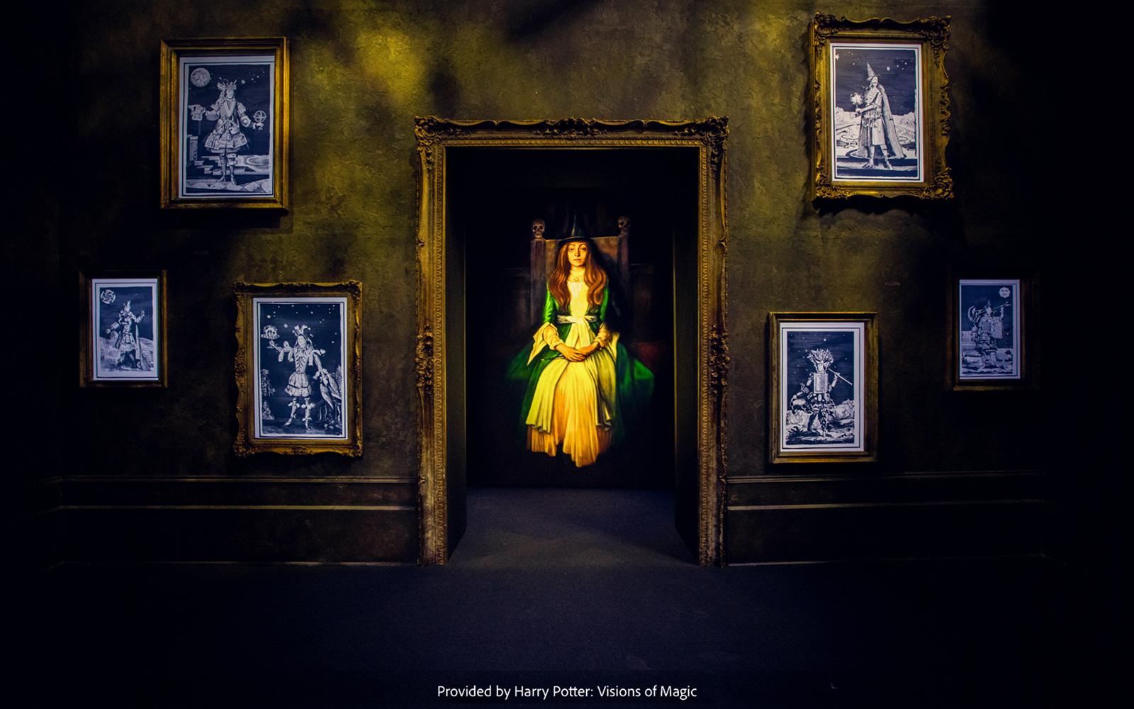 Framed magical portraits in a dimly lit room at Harry Potter: Visions of Magic exhibit.