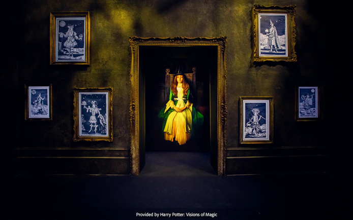 Framed magical portraits in a dimly lit room at Harry Potter: Visions of Magic exhibit.