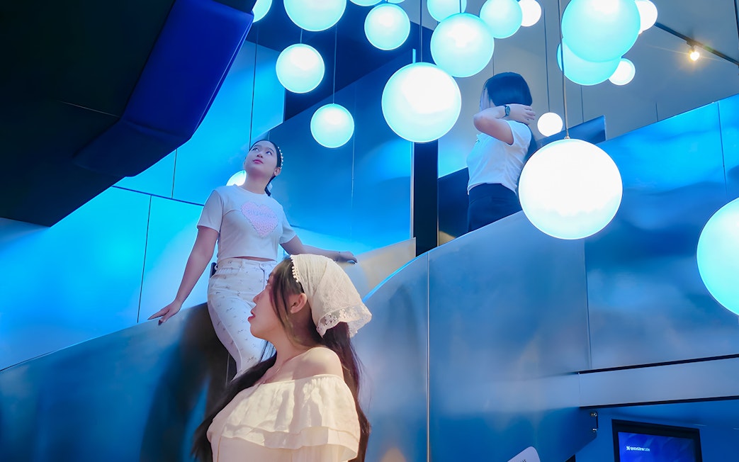 Visitors exploring the illuminated Space & Time Cube exhibit in Bangkok.