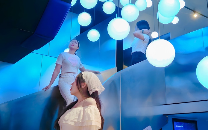 Visitors exploring the illuminated Space & Time Cube exhibit in Bangkok.