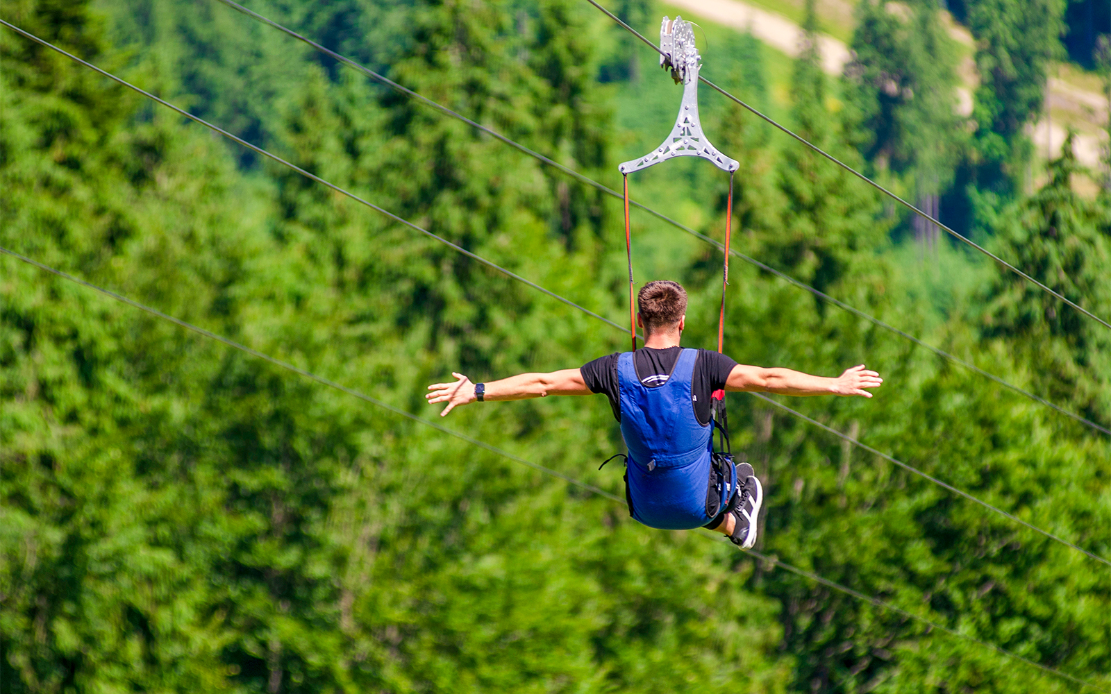 Visitors enjoying the ESCAPE Penang Kite Flyer ride, soaring above lush greenery in Penang, Malaysia.