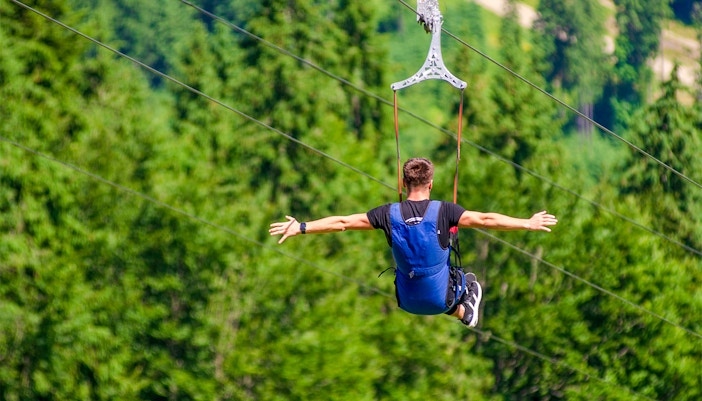 Visitors enjoying the ESCAPE Penang Kite Flyer ride, soaring above lush greenery in Penang, Malaysia.