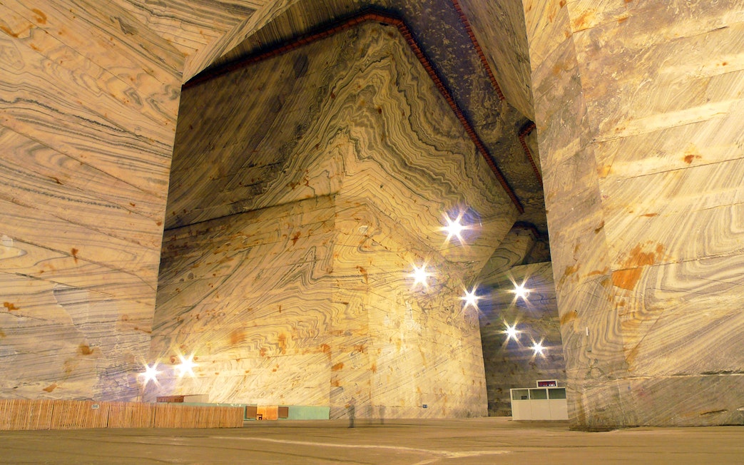 Slanic Salt Mine's vast underground chamber with illuminated salt walls in Bucharest.