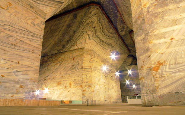 Slanic Salt Mine's vast underground chamber with illuminated salt walls in Bucharest.