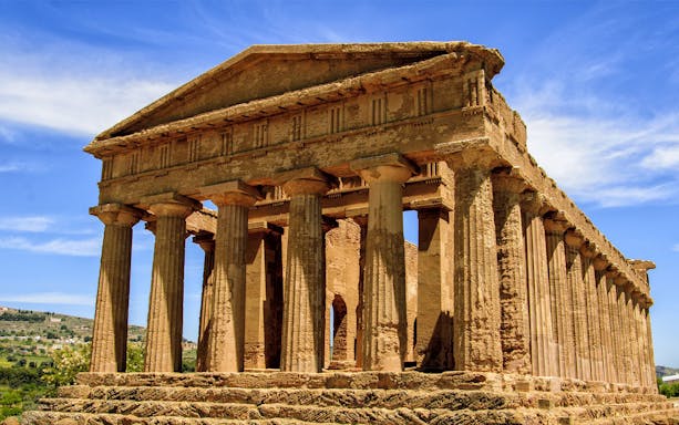 Ancient Greek temple in Agrigento, Sicily, under a clear blue sky.