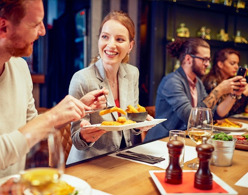 Dining experience at Opéra-Grand Café Capucines, Paris with people enjoying food and drinks.
