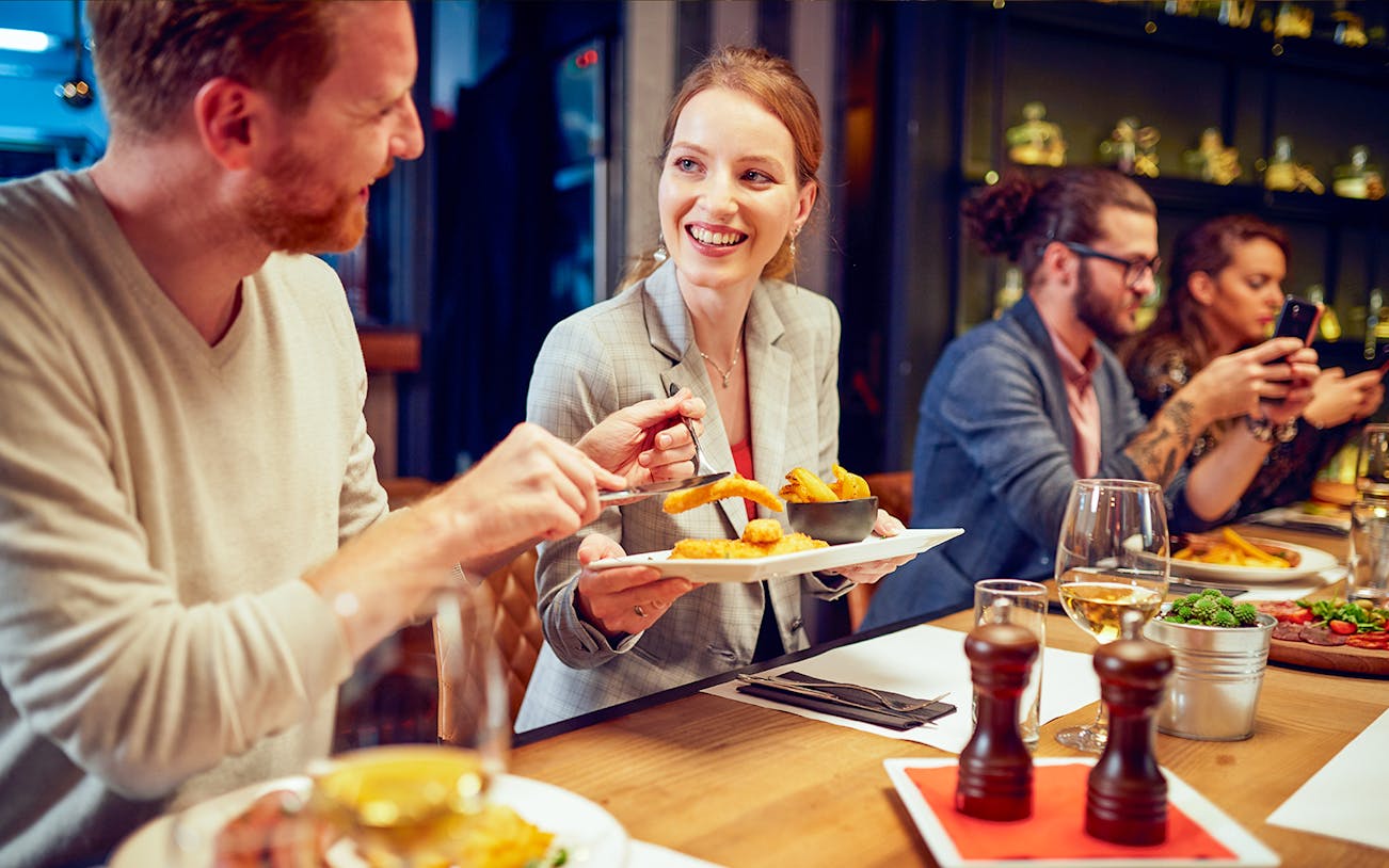 Dining experience at Opéra-Grand Café Capucines, Paris with people enjoying food and drinks.
