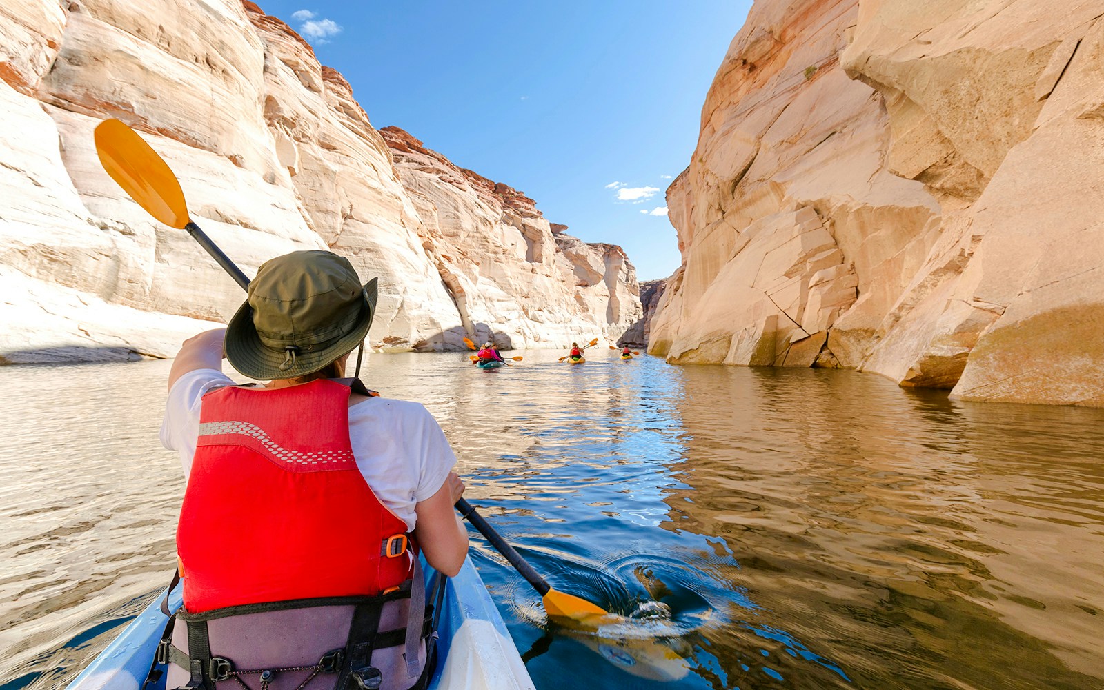 Kayakers paddling through narrow canyons on Lake Powell.