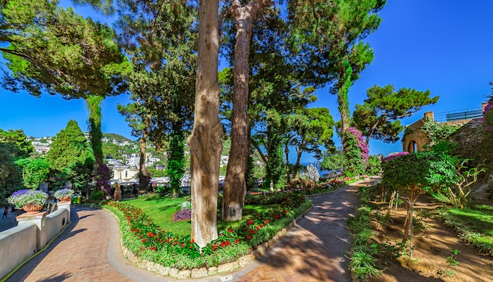 Gardens of Augustus, Capri with vibrant flowers and view of Faraglioni sea stacks.