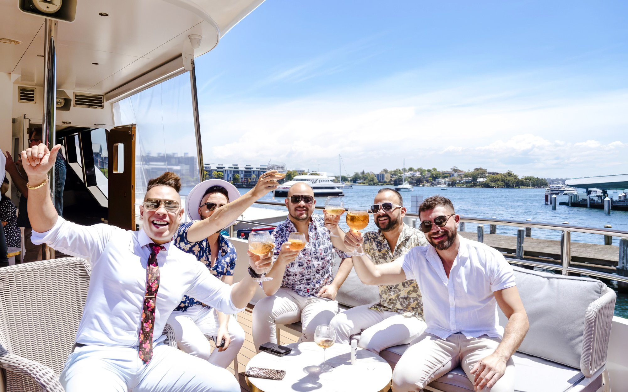 Group enjoying drinks on The Jackson during Chandon Harbour Long Lunch, with waterfront view.
