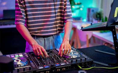 DJ mixing music on a controller in a vibrant studio setting.