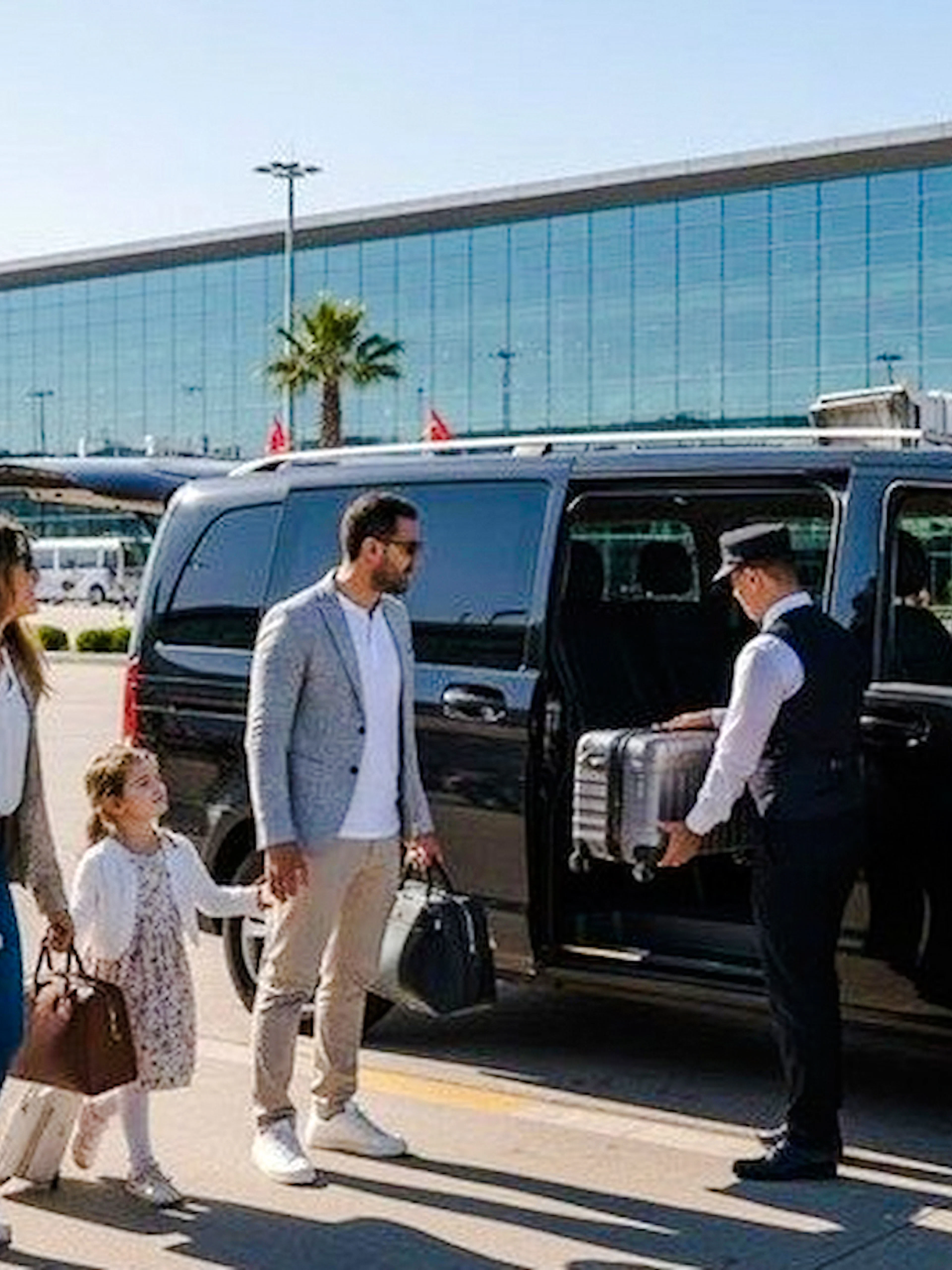 Family using private transfer service at Marrakech Airport with driver loading luggage.