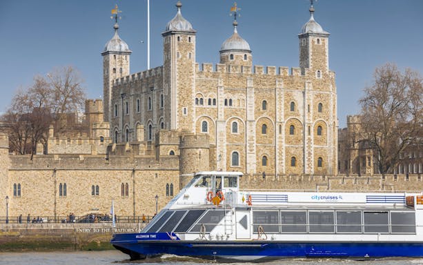 Cruise boat on River Thames passing the Tower of London.