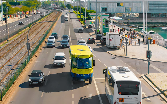 HIPPOtrip vehicle driving on a city road alongside cars and a tram line.