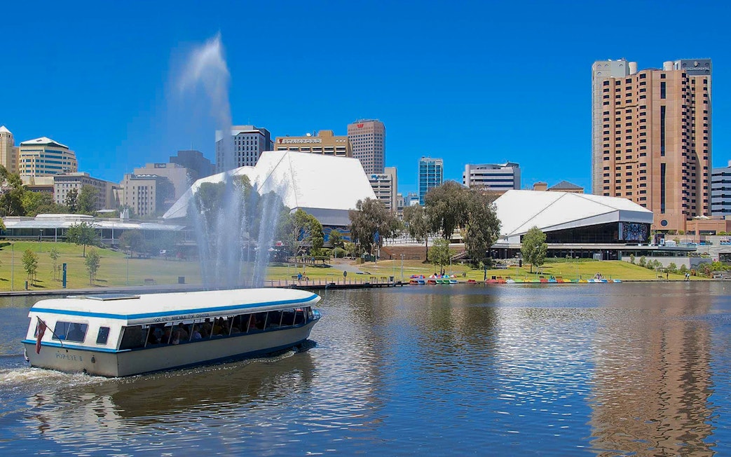 River cruise boat on Torrens River with Adelaide skyline in the background.