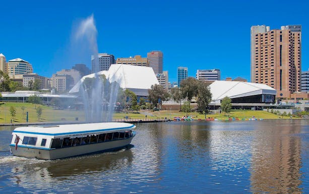 River cruise boat on Torrens River with Adelaide skyline in the background.