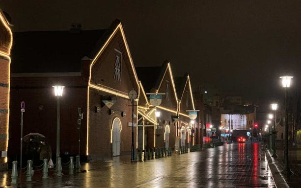 Night view of Kanemori Red Brick Warehouses in Hakodate, Japan, illuminated with lights.