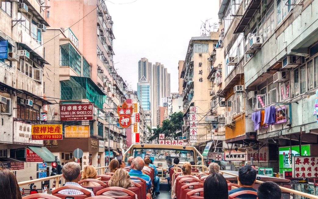 Guests on a Big Bus tour in Hong Kong, viewing bustling city streets and high-rise buildings.