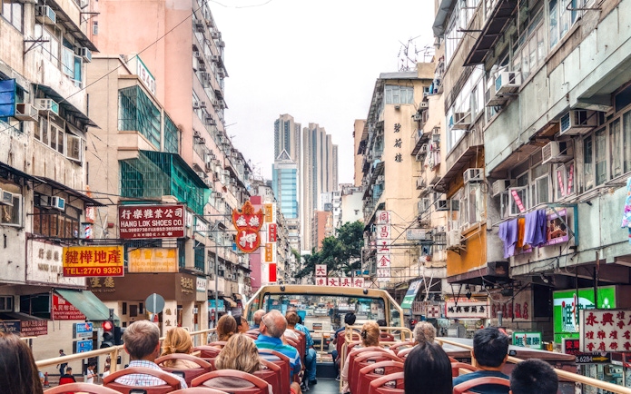 Guests on a Big Bus tour in Hong Kong, viewing bustling city streets and high-rise buildings.